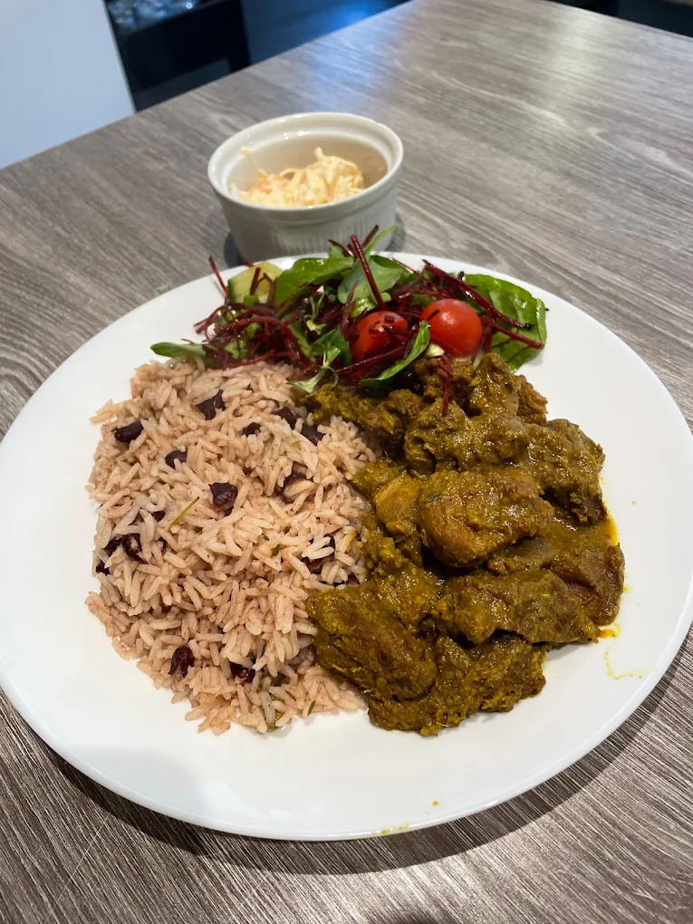 Orlenes Kitchen Caribbean curry dish with rice, beans, and fresh salad - authentic Jamaican fusion cuisine
